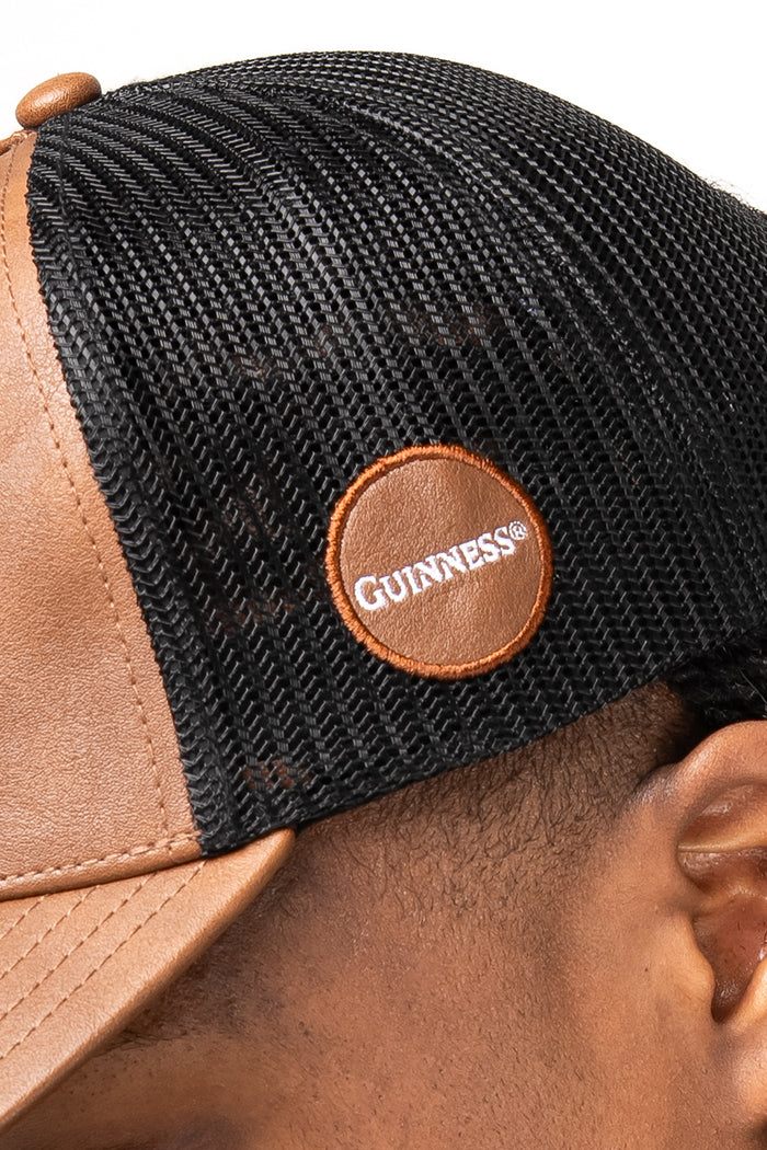 Black and brown cap with a Guinness logo on a white background