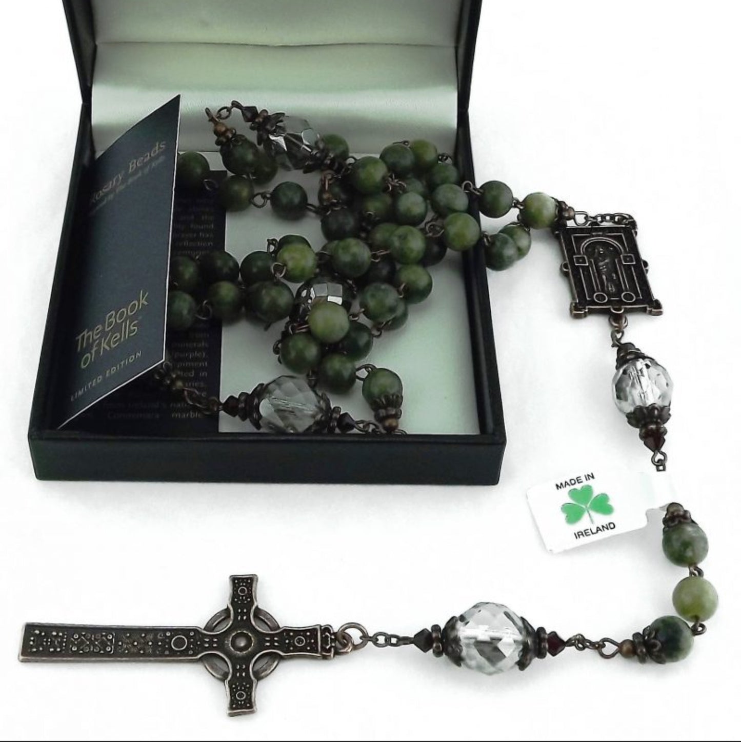 Green rosary with silver and black accents in a black box on a white background