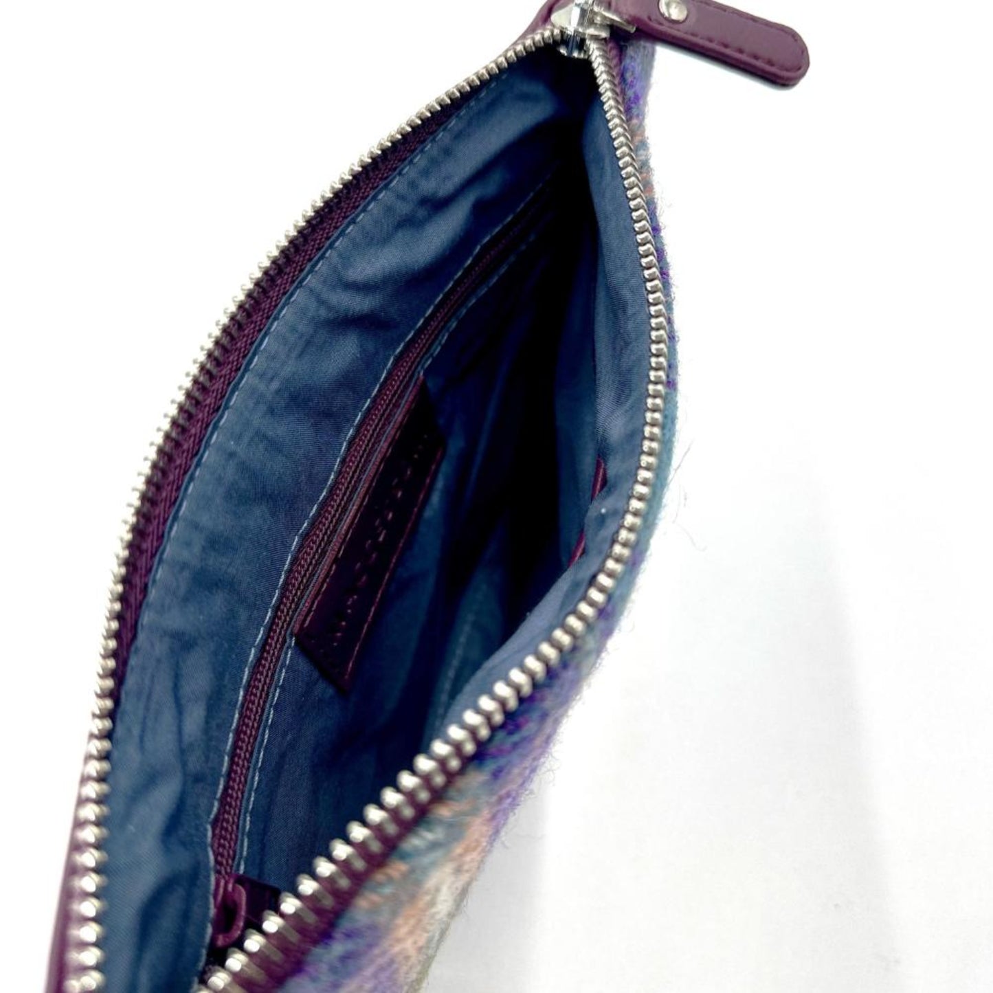 Open plaid clutch bag with a visible zipper on a white background