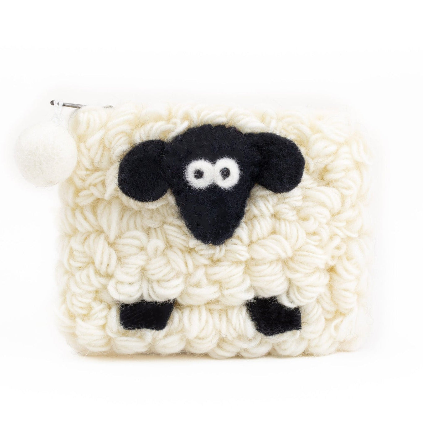 A knitted wool purse shaped like a sheep, primarily in white with black details for the face.