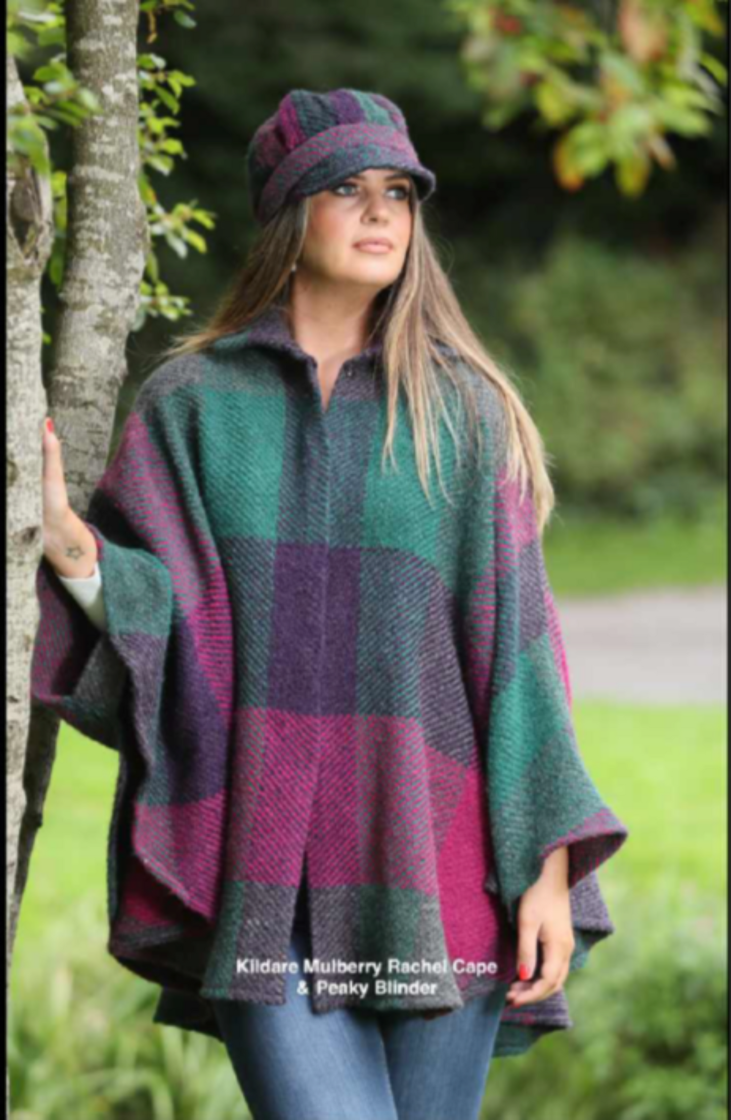Woman wearing a plaid poncho and hat outdoors