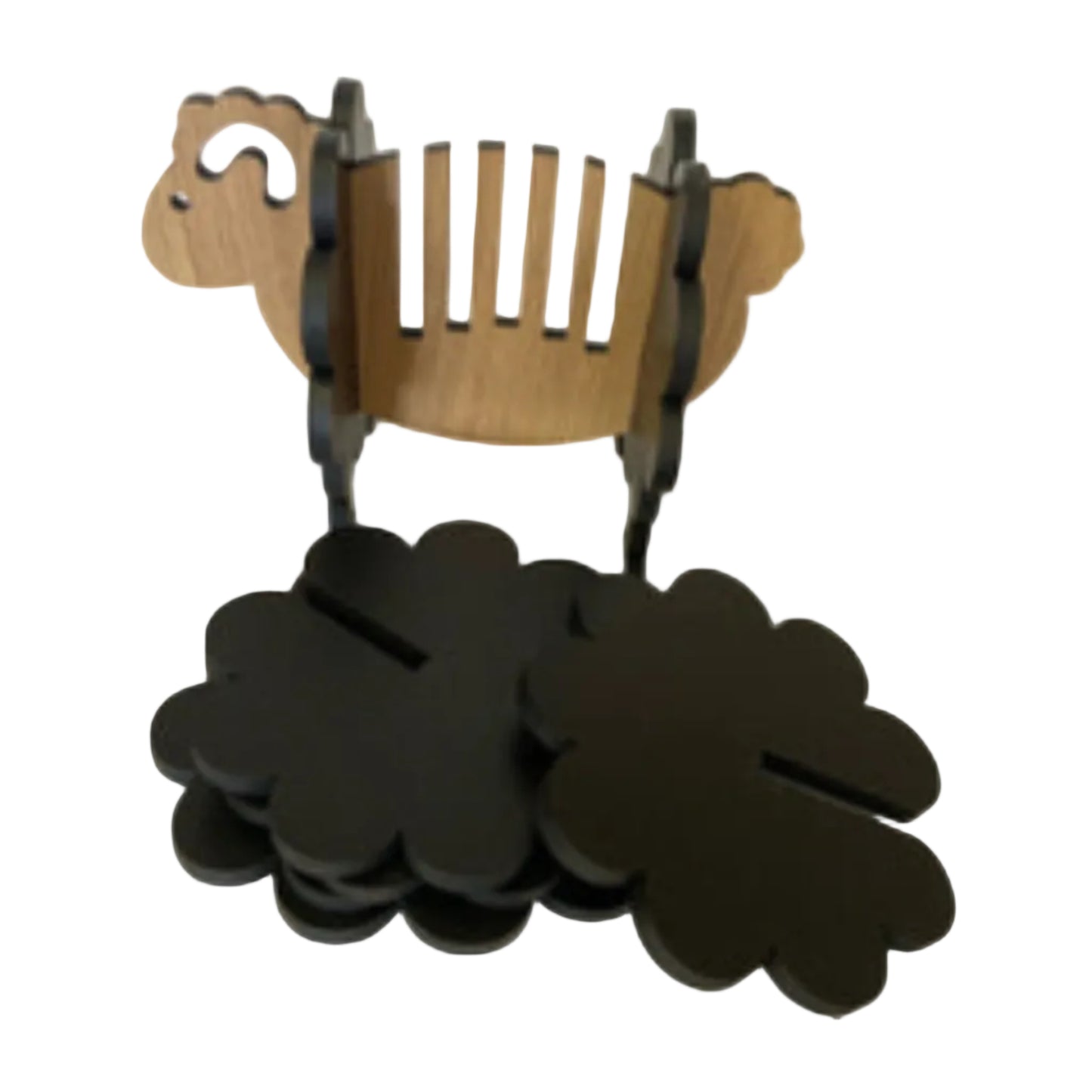 Wooden sheep-shaped holder with black cloverleafs on a white background