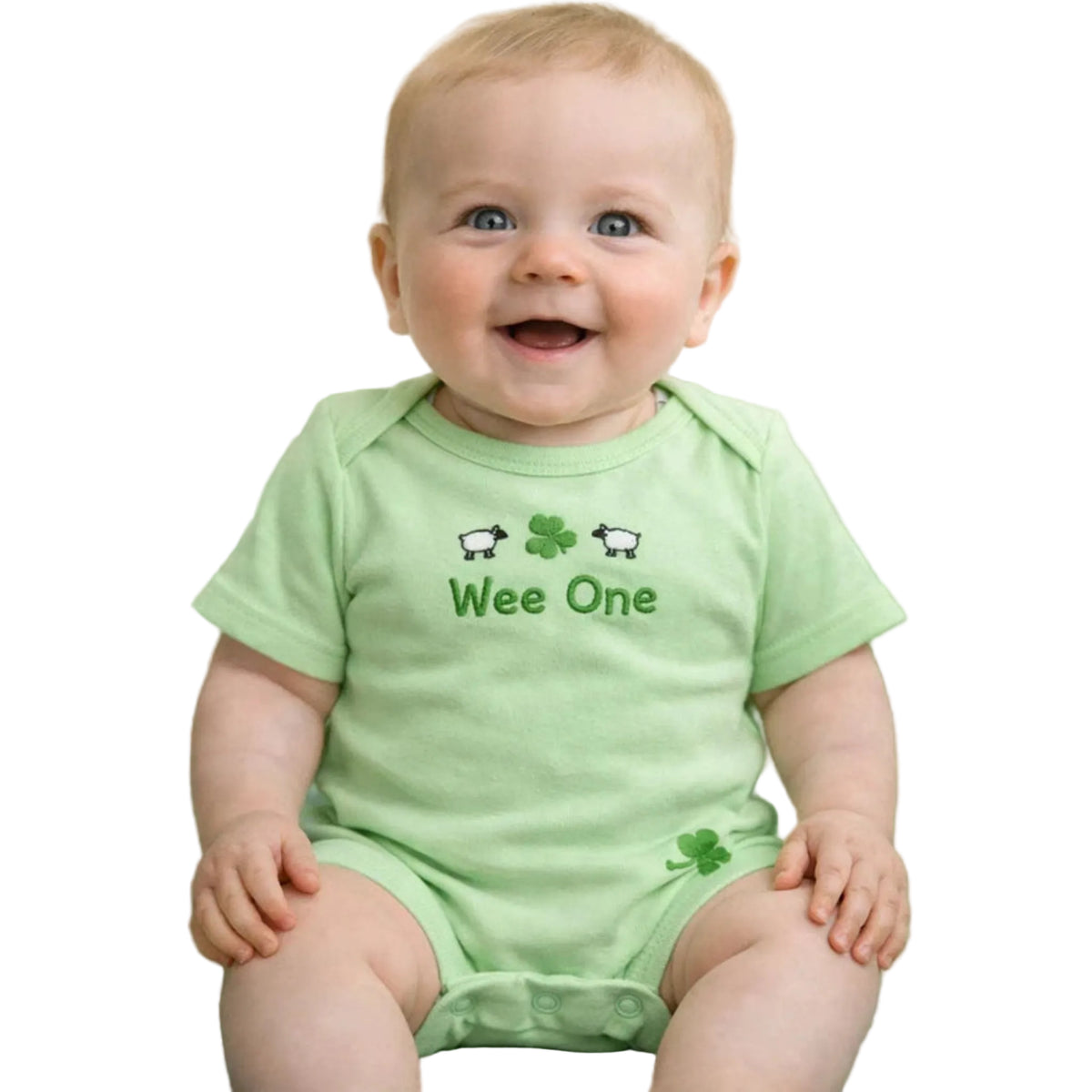 Baby wearing a green onesie with 'Wee One' text and shamrock designs on a shamrock patterned background.