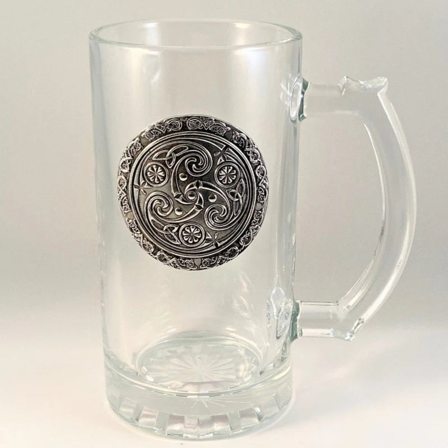 A set of clear glass beer tankards with pewter detailing, displayed on a table with autumnal decorations.