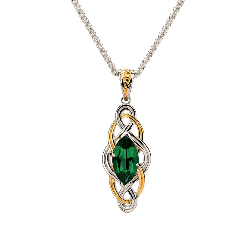 Jewelry pendant with green gemstone and gold and silver design on a white background
