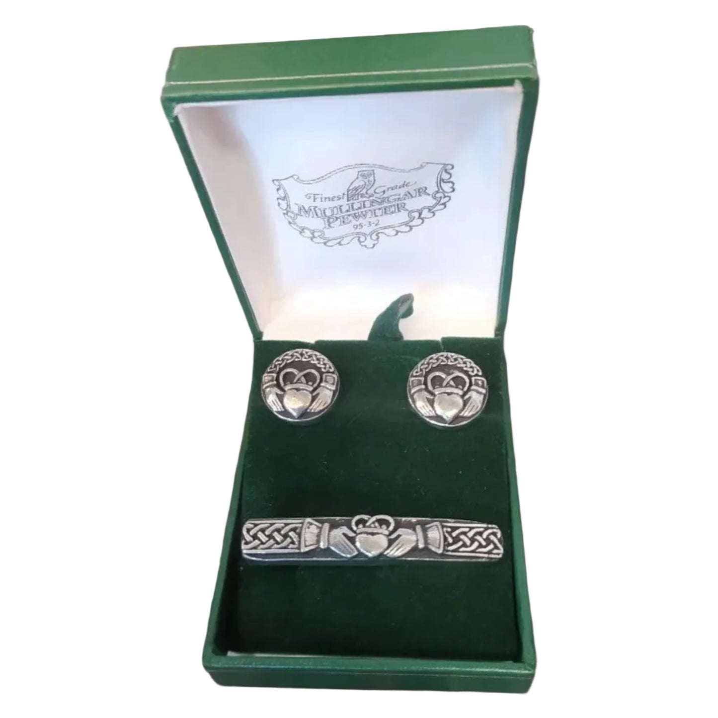 Celtic knot cufflinks and tie clip set in a green box on a red leather surface.