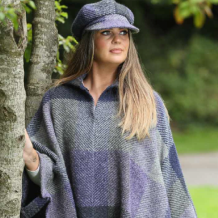 Woman wearing a patterned cape and cap outdoors