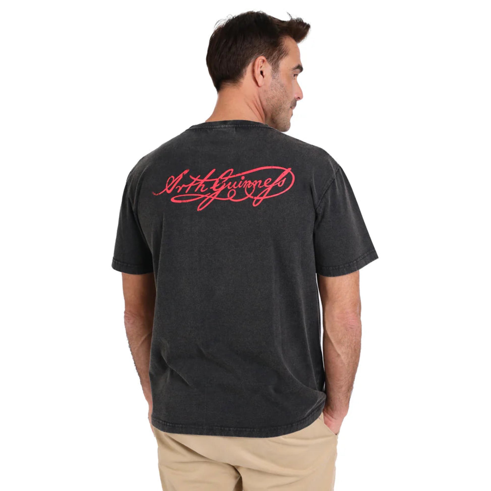 Man wearing a black shirt. The back says "Arth Guinness" in red stylized cursive.