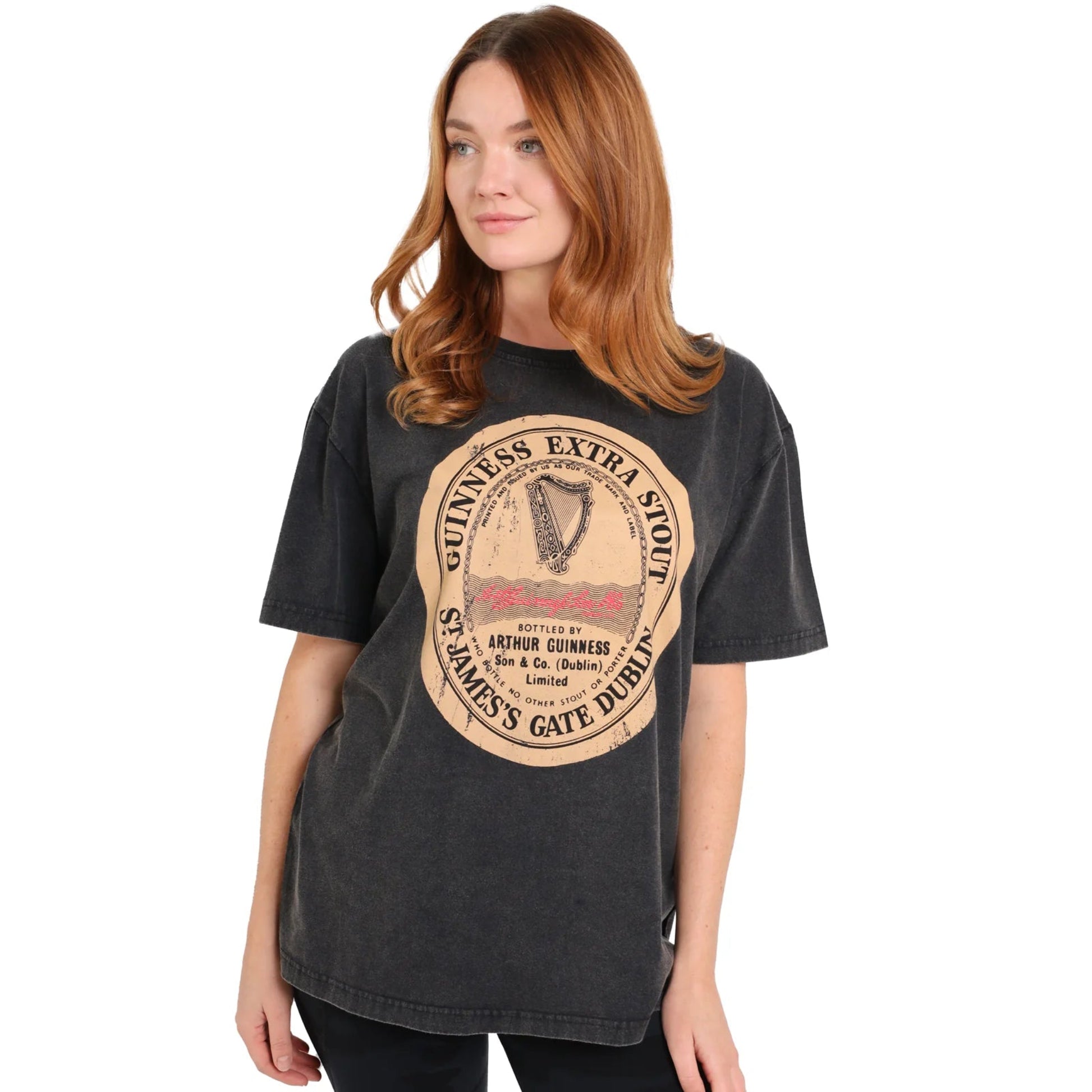 Woman wearing a black tee shirt with a large guinness stamp logo on the front. 