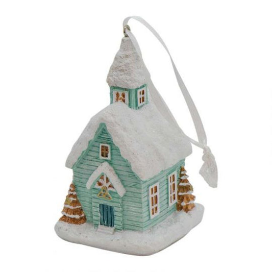 A christmas ornament of a snowy church with a trinity knot above the door.