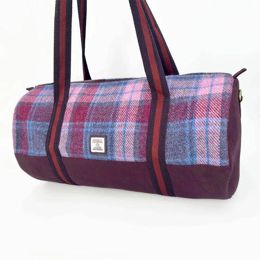 Plaid duffel bag with a visible brand label on a white background