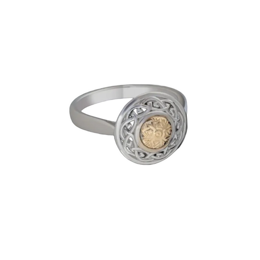 A silver ring with an intricately carved shield-shaped top and an 18k gold bead in the center,