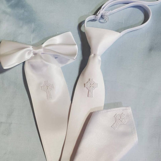 White satin bow tie and pocket square with embroidered crosses on a light blue background