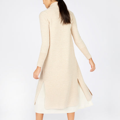 Woman wearing a long beige cardigan on a white background
