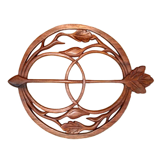 Decorative wooden wall art with circular design and leaf elements on a stone background