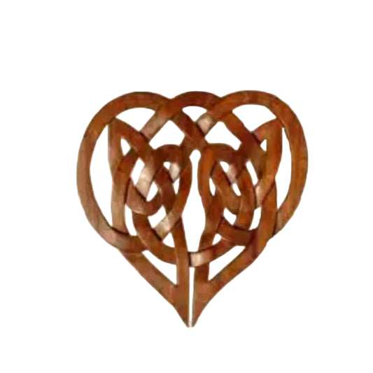 Decorative metal heart with Celtic knot design on a beige background