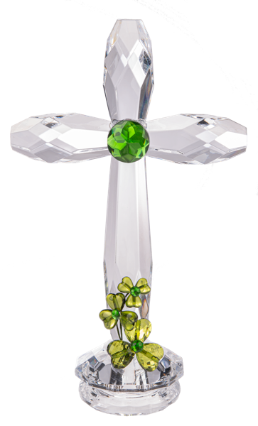 A decorative standing shamrock cross with a clear body and green shamrock at the base, surrounded by small green and yellow flowers.