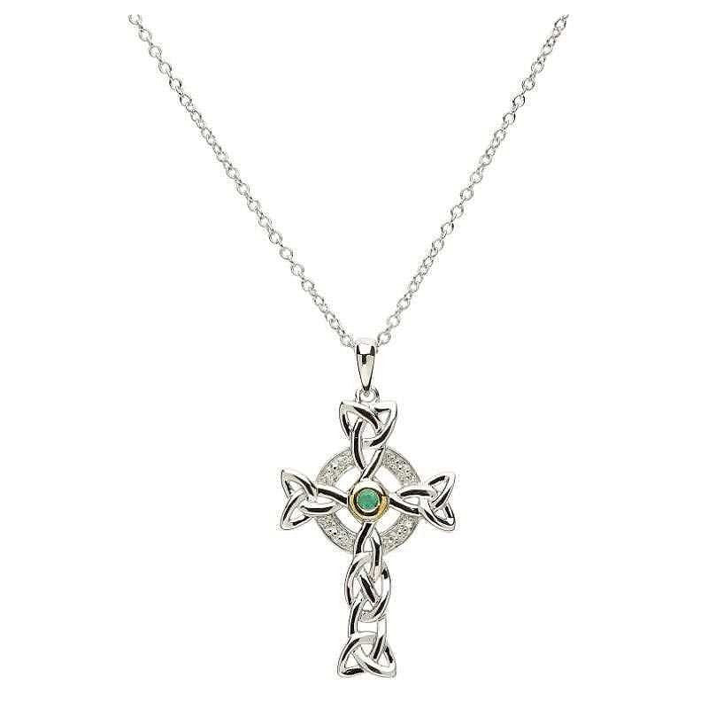 A silver Celtic cross necklace with a trinity knot design, encrusted with small diamonds and a central emerald.