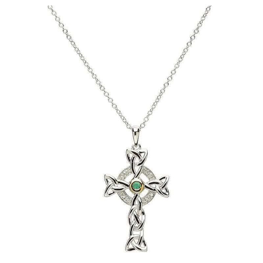 A silver Celtic cross necklace with a trinity knot design, encrusted with small diamonds and a central emerald.