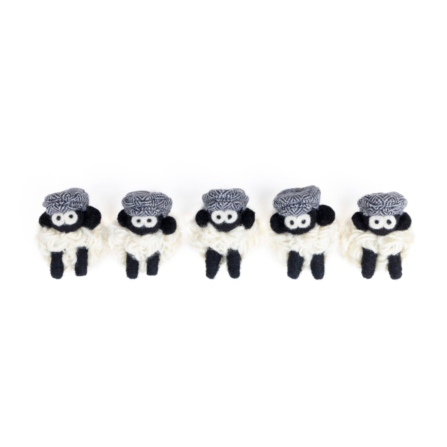 Five small knit sheep with blue flat caps