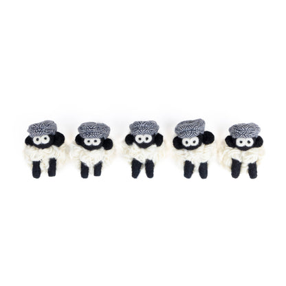 Five small knit sheep with blue flat caps