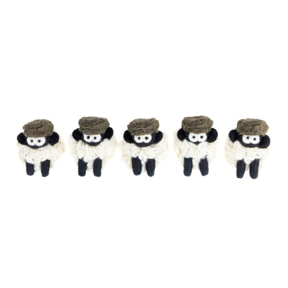 Five small knit sheep with brown flat caps