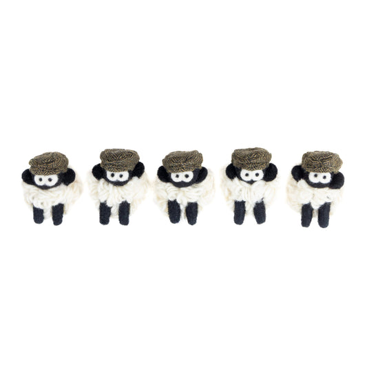 Five small knit sheep with brown flat caps