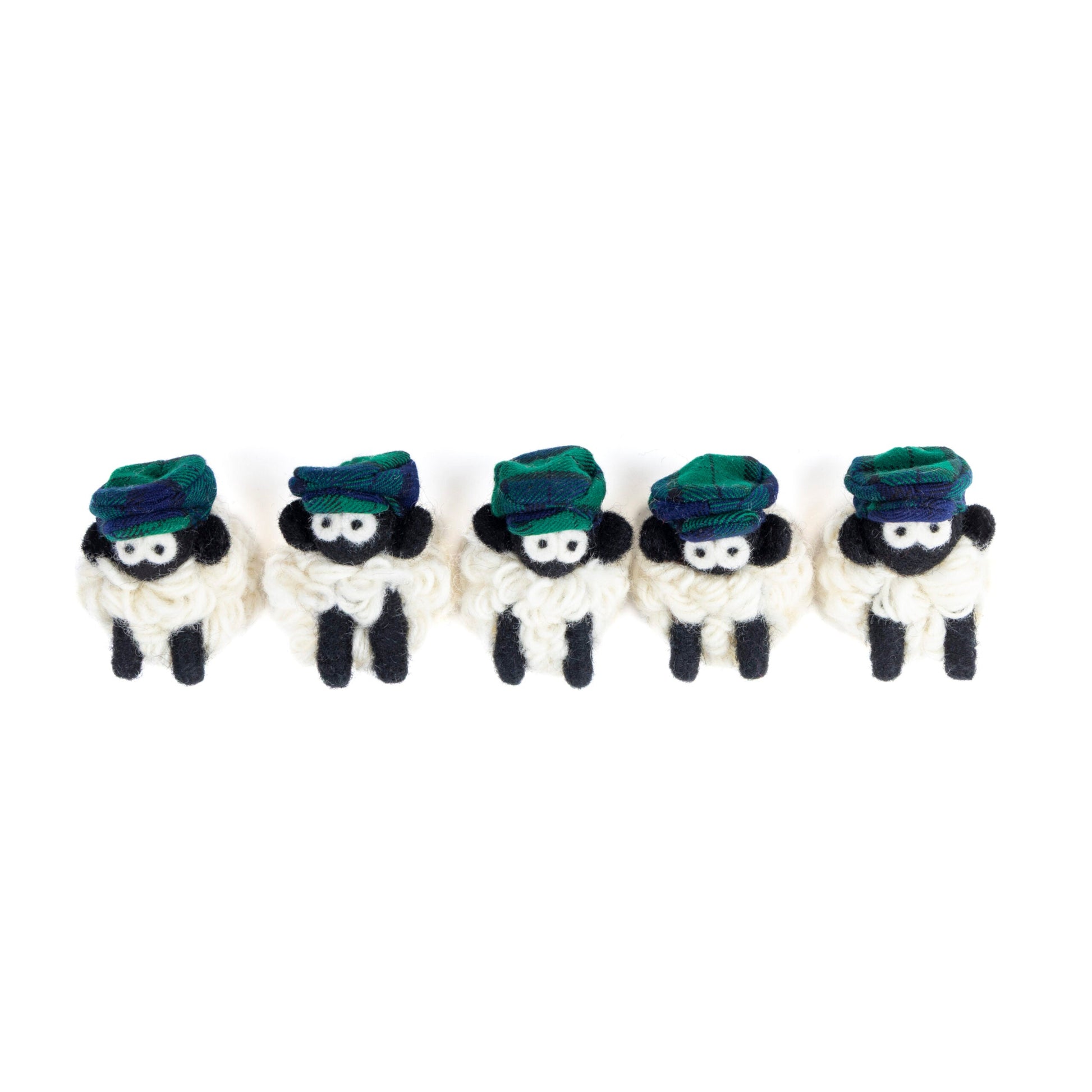 Five small knit sheep with green flat caps