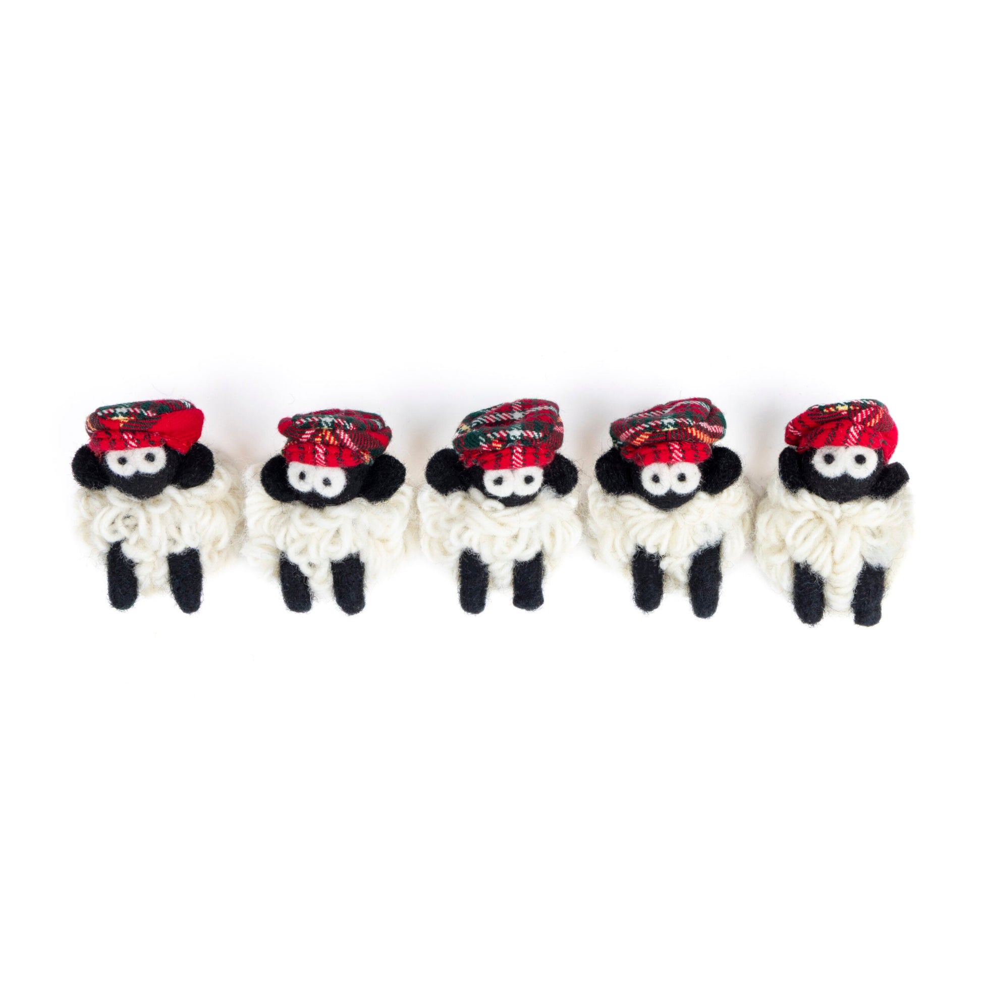 Five small knit sheep with red flat caps