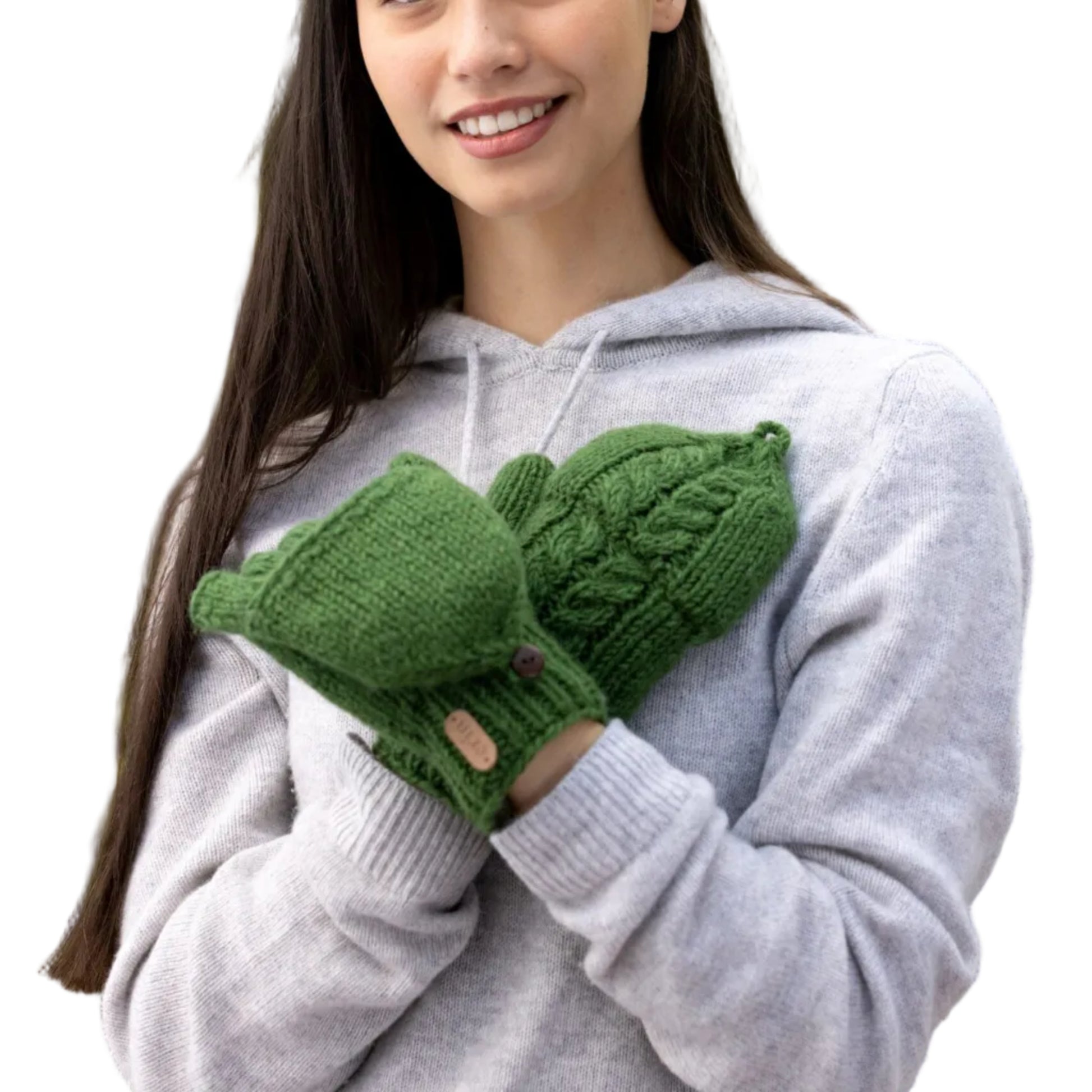 Woman wearing pair of green knit mittens. Top of one mitten is removed to reveal fingerless gloves underneath. 