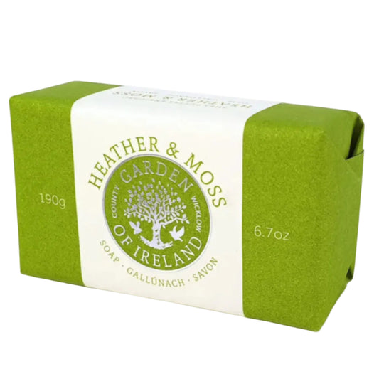A bar of heather and moss soap in green and white paper packaging