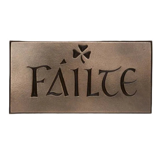 A bronze rectangular plaque with the word failte engraved into it. A small shamrock engraved by the top.