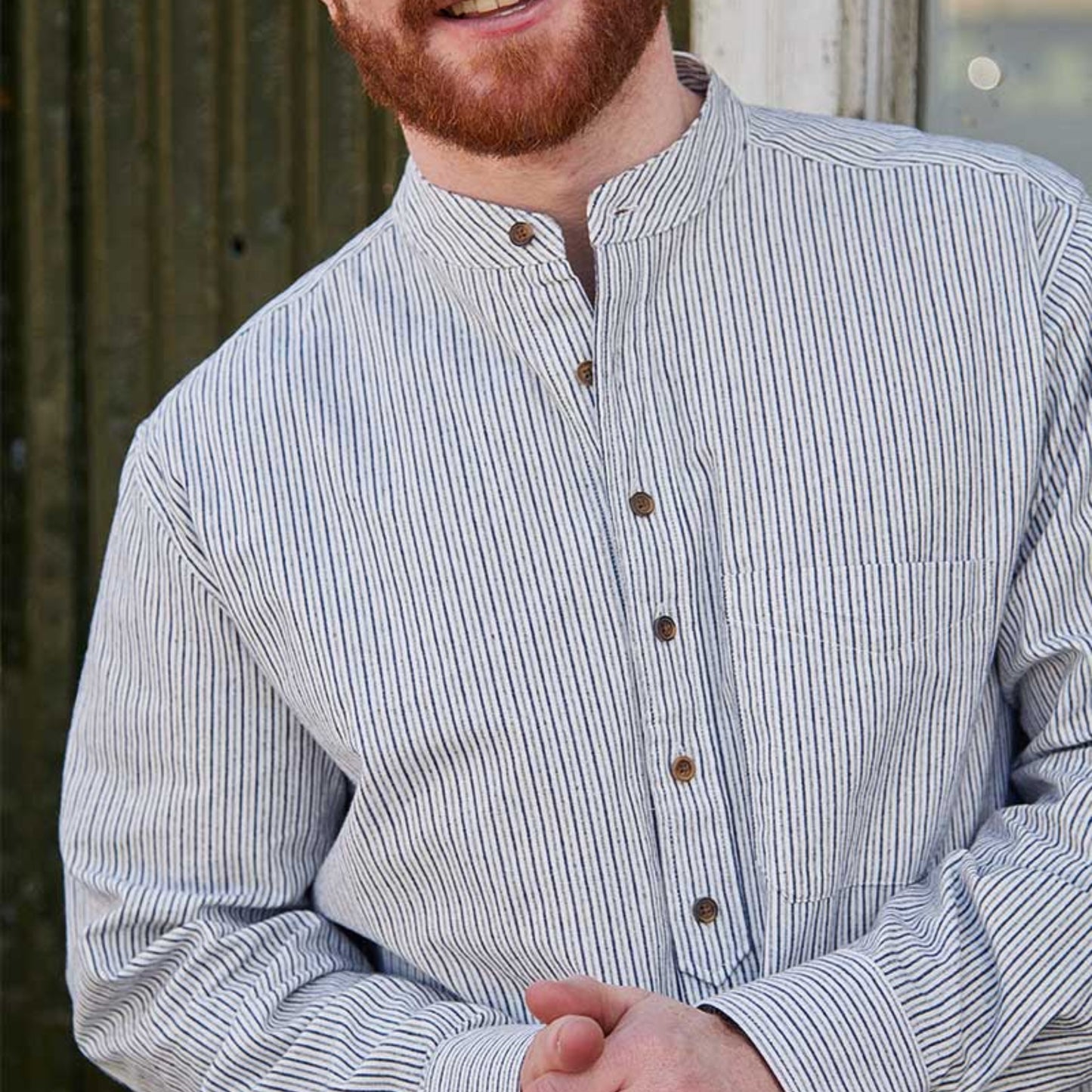 Man wearing a striped shirt with a blurred background