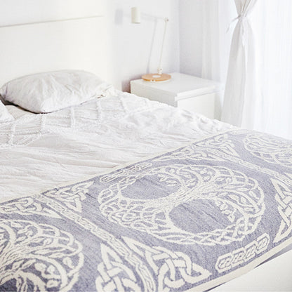 Bed with a patterned gray and white comforter in a bedroom setting.