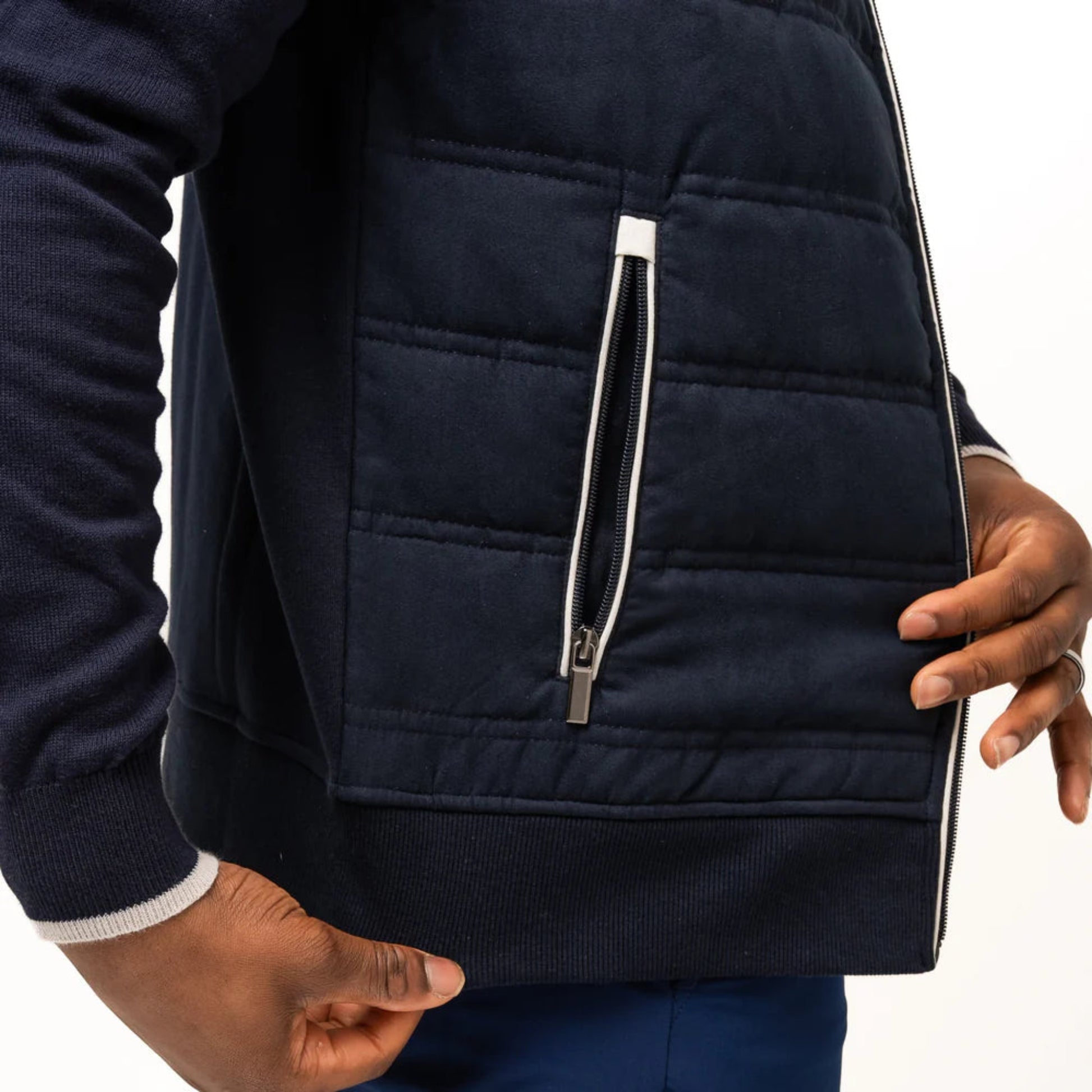 Closeup of an open zipper pocket on a navy vest.