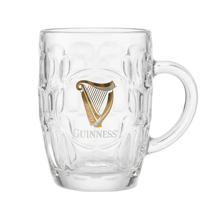 Glass tankard with uniform divots all around and a gold Guinness harp on the front.