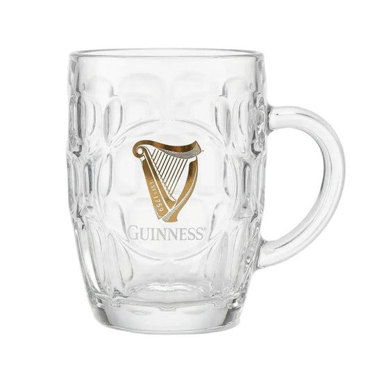 Glass tankard with uniform divots all around and a gold Guinness harp on the front.