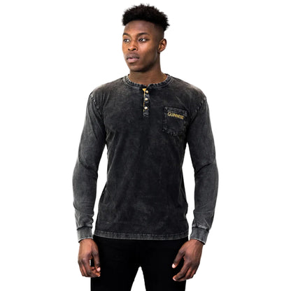 Man wearing a black long-sleeve shirt with gold buttons and "Guinness" written on the breast pocket.