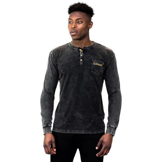 Man wearing a black long-sleeve shirt with gold buttons and "Guinness" written on the breast pocket.