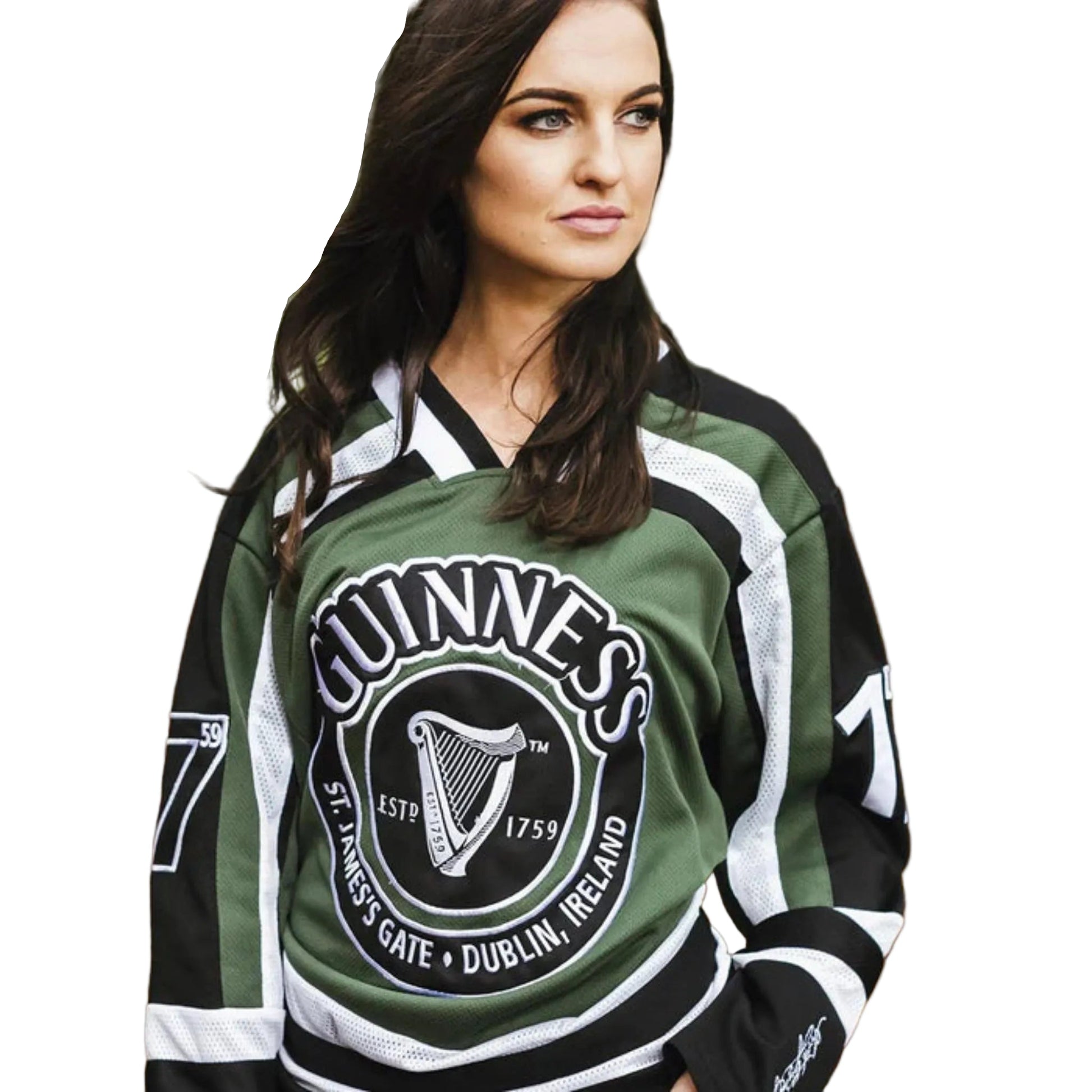 A woman looking off into the distance while wearing a green Guinness hockey jersey. 