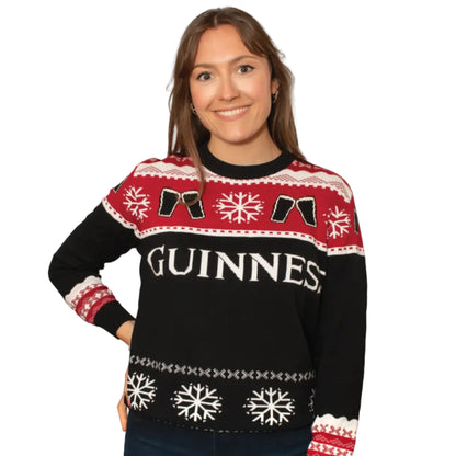 A woman wearing a black and red Guinness holiday sweater with a beer and snowflake pattern.