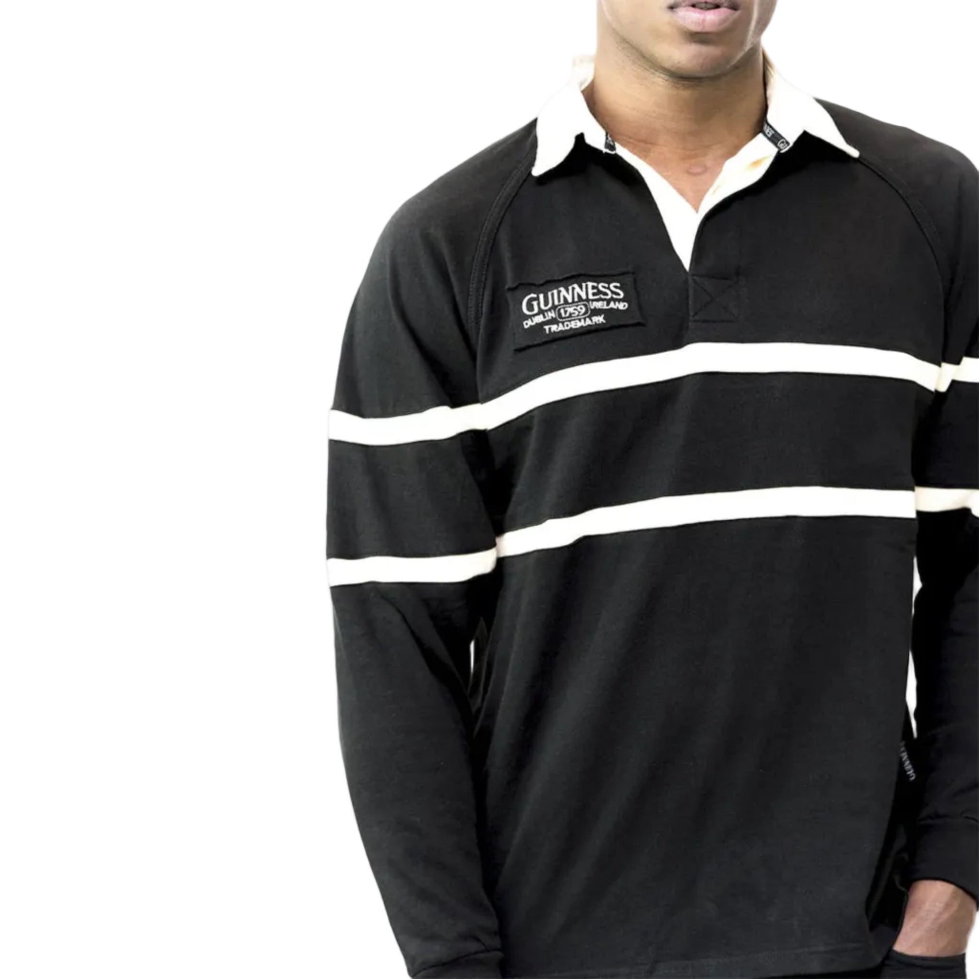 Close-up of a man wearing a striped rugby shirt with a Guinness logo patch on the right chest. 