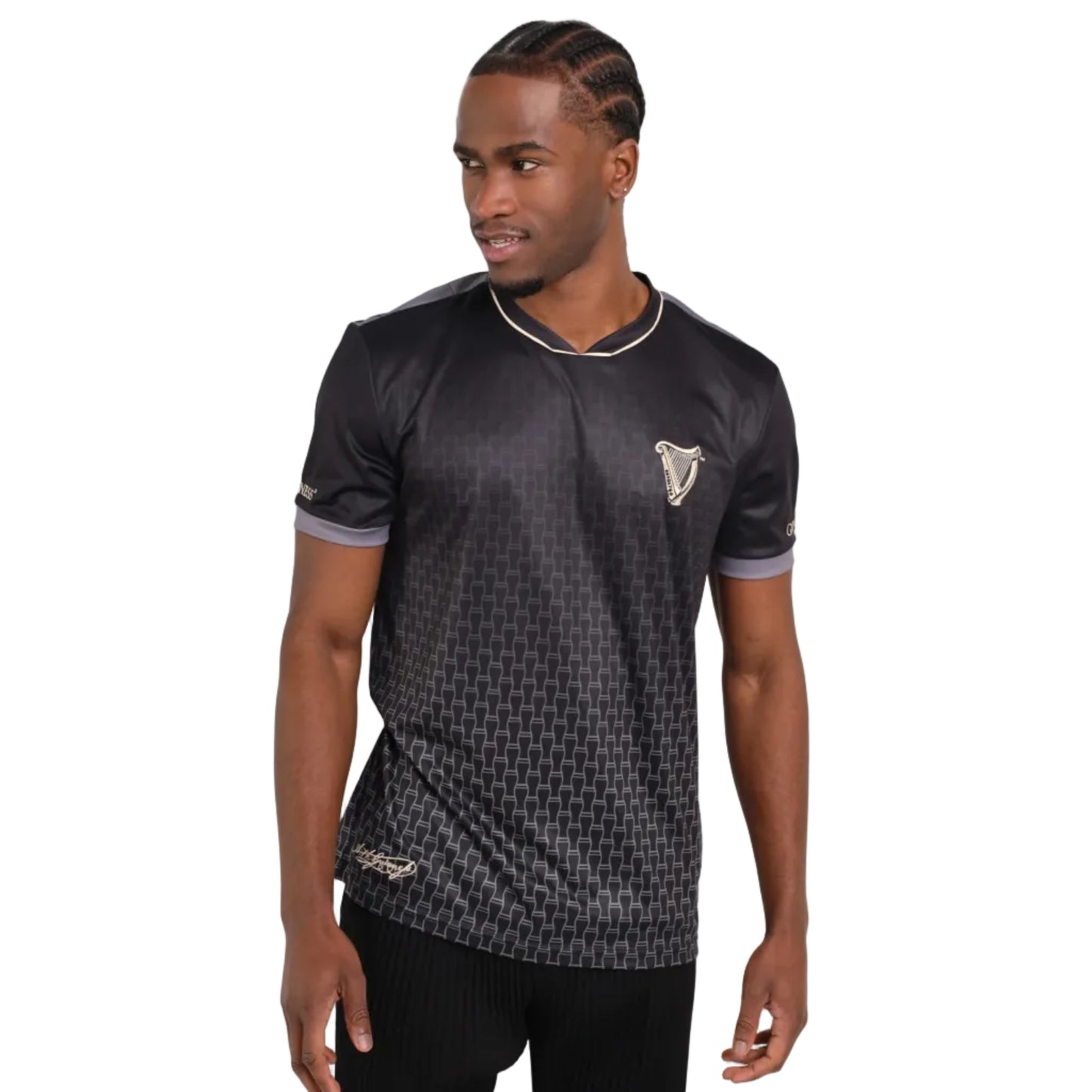 Man wearing a black soccer jersey with a tiny pint glass ombre print and a harp on the left chest.