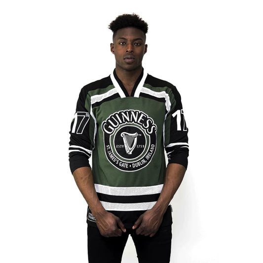 Person wearing a green and black sports jersey with Guinness logo on a white background