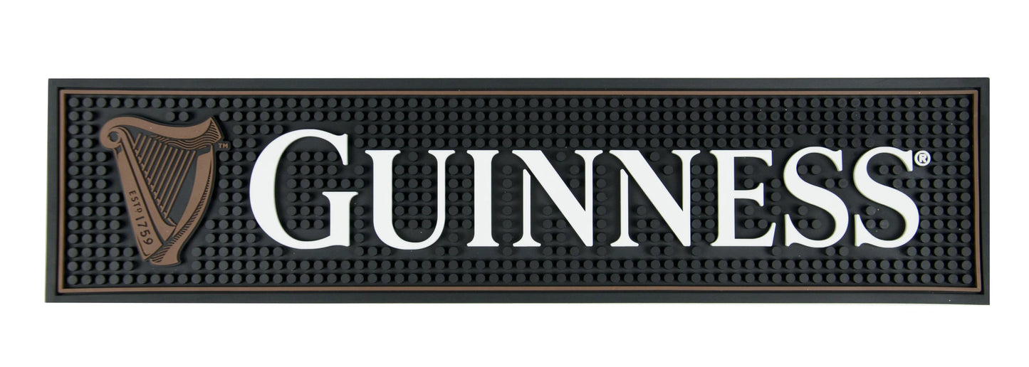 Guinness logo on a black bar mat with a harp symbol