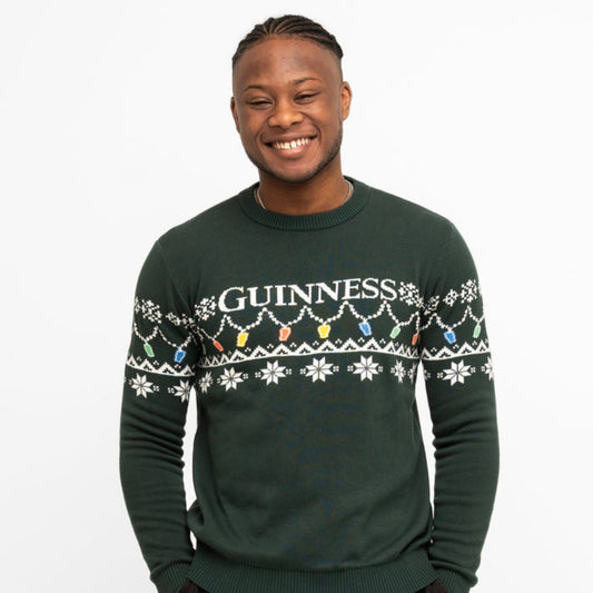Man wearing a green Guinness sweater with festive design on a white background