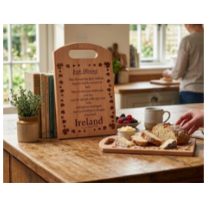 Wooden cutting board with engraved text on a kitchen counter with bread and coffee.