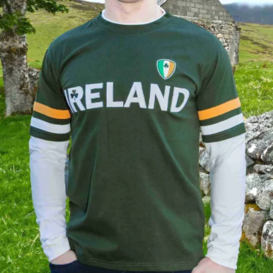 Man wearing a green 'IRELAND' t-shirt with a crest in a scenic outdoor setting.