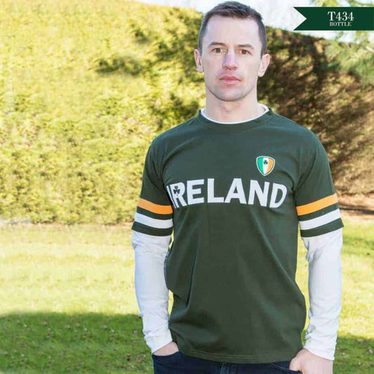 Man wearing a green 'IRELAND' t-shirt with a flag design outdoors.