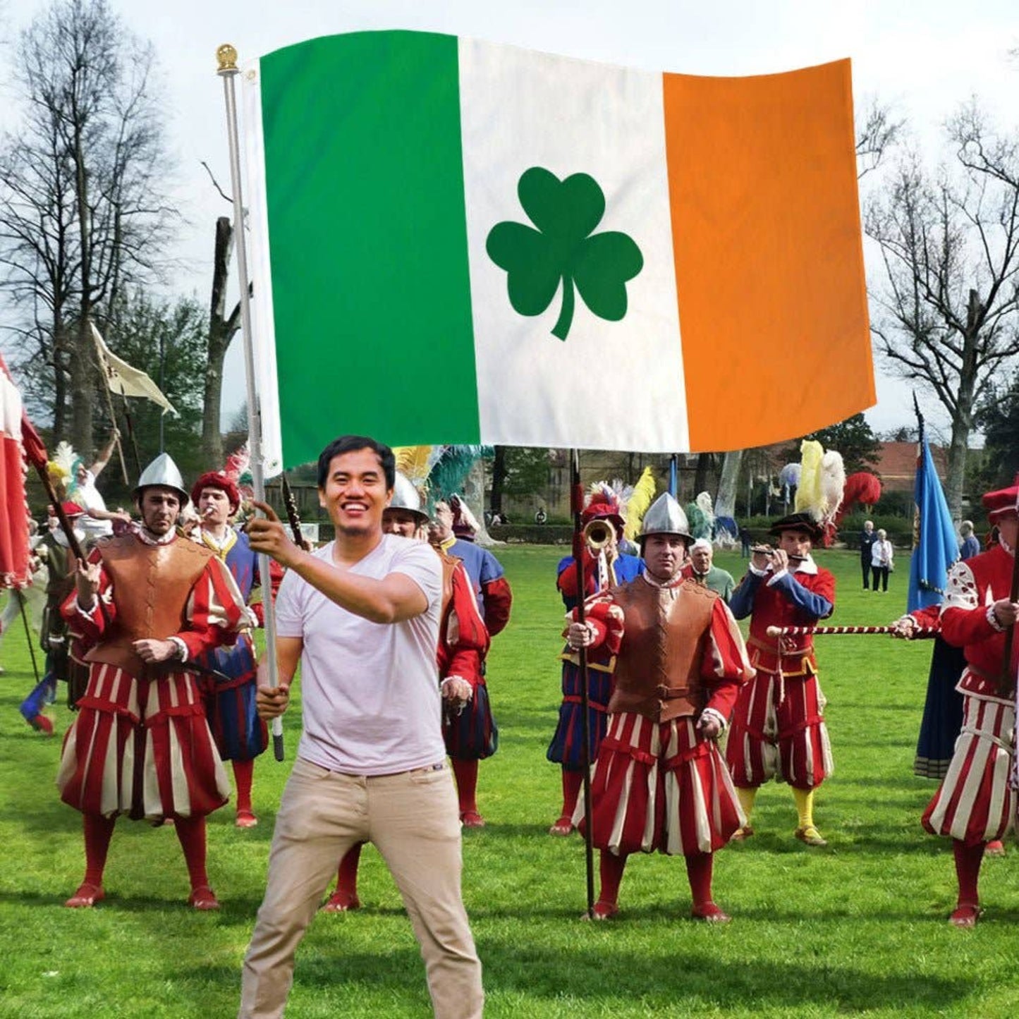 Man flying an Irish clover flag at a festive outdoor event.